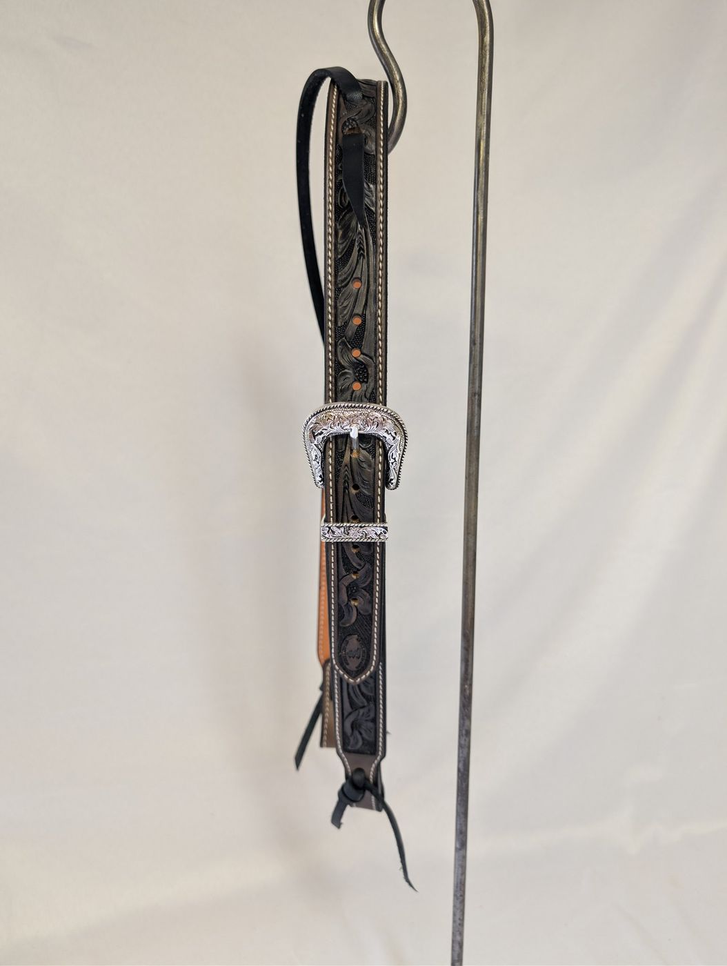 Gray and black hand-tooled leather headstall with engraved silver buckle