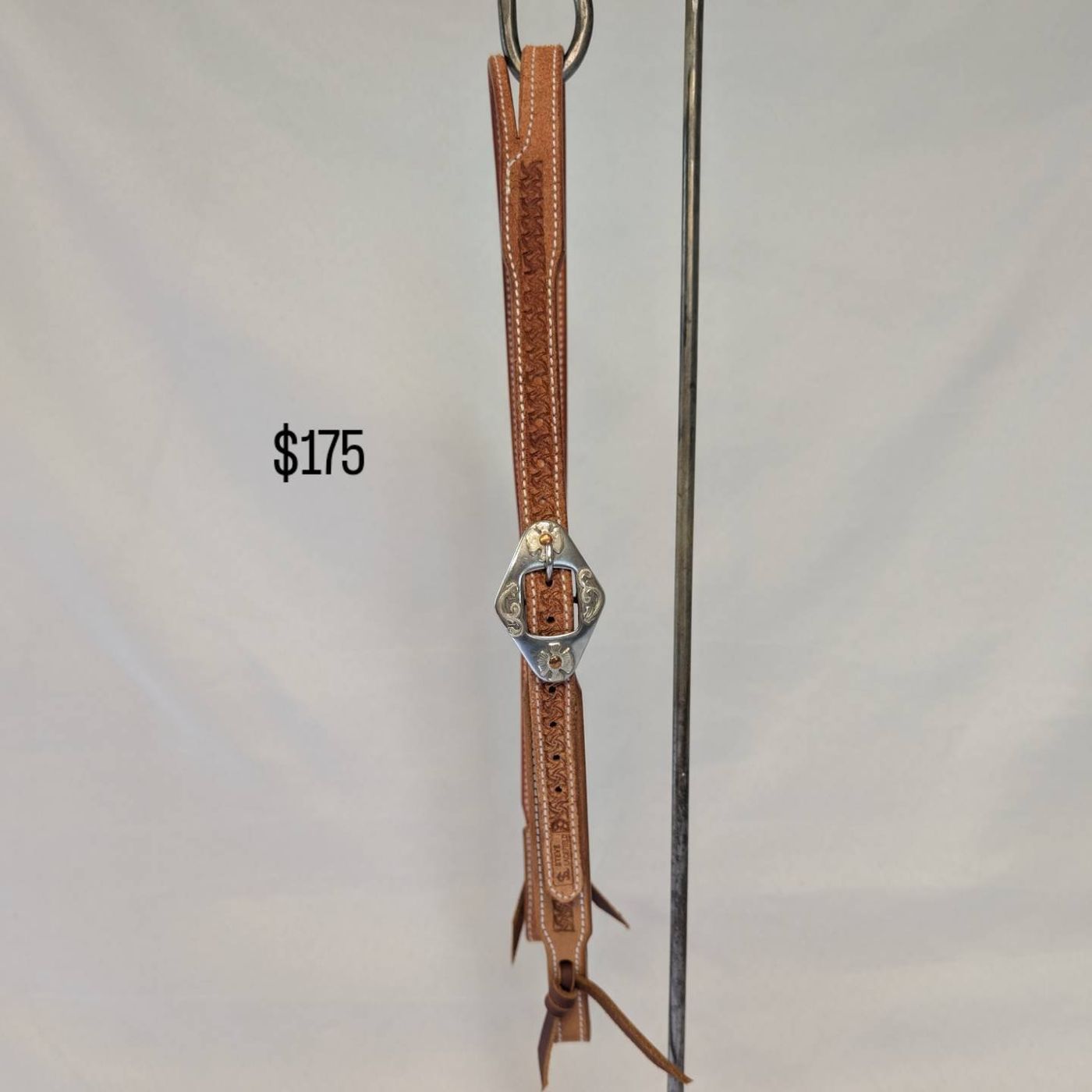Tan floral-stamped headstall with engraved silver buckle, number 2