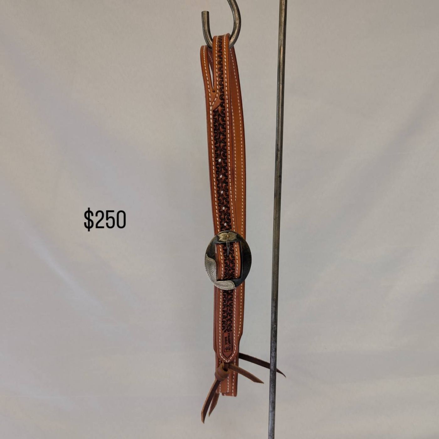 Tan basket-stamped headstall with engraved silver and black buckle